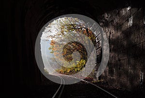 A railway coming out of the tunnel and the autumn light  and the light at the end of the tunnel