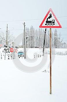 Railway crossing without a barrier with a lot of warning signs in the snowy winter season