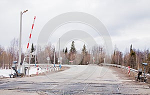 Railway crossing with a barrier near the forest