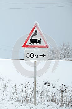 Railway crossing without barrier. A road sign depicting an old black locomotive, located in a red triangle