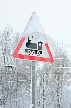 Railway crossing without barrier. A road sign depicting an old black locomotive, located in a red triangle