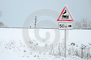 Railway crossing without barrier. A road sign depicting an old black locomotive, located in a red triangle