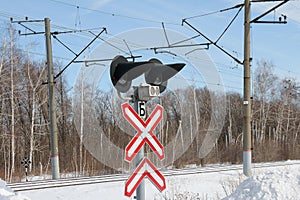 Railway crossing sign with signal lights in winter