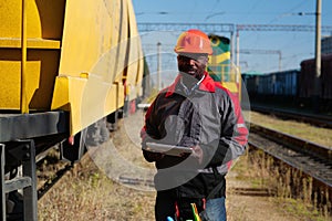 Railway employee holds in hands tablet pc and look at camera