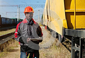 Railway employee holds in hands tablet pc and look at the camera