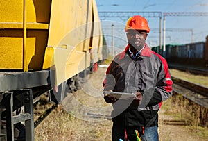 Railway employee holds in hands tablet pc and look at the camera