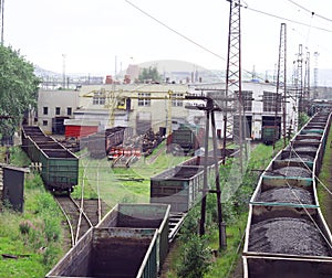 Railway freight cars are empty and loaded with coal in the car repair depot.