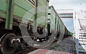 Railway freight cars pass by. Movement of a freight train past the station platform. Wagons carrying cargo. Traffic in the frame a