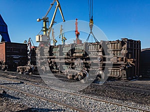 A railway gondola car that fell on its side is hoisted. photo