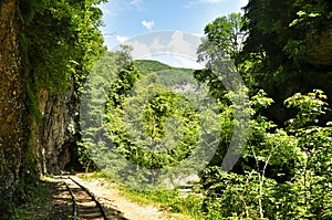 Railway in Guam gorge on one side of the rocks, the other a deep precipice and seething fast river