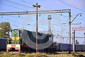 Railway landscape. Many railroad cars and tanks standing in rails. Public address horn loud speakers on wooden pole over blue sk