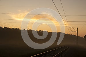 Railway leaving for the horizon in the autumn forest in the morning mist