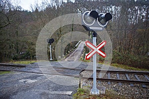 Railway level crossing marked with traffic lights and signs