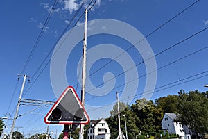 A railway level crossing with traffic lights and raised ramps located in the vicinity of train station.