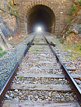 Railway with light at the end of the tunnel.