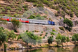 The railway line runs parallel to the river in the wine-growing region of the Douro Valley, Portugal photo