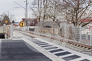 a railway platform and a road sign prohibiting crossing the rails on foot