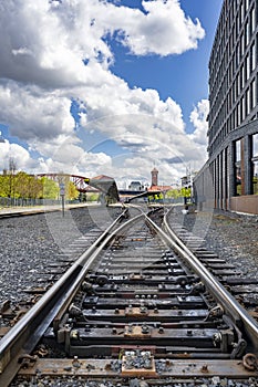 Railway rails with cross ties with a distribution switch and the old railway station in Portland