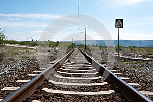 Railway rails with electric poles and in the background of the mountain