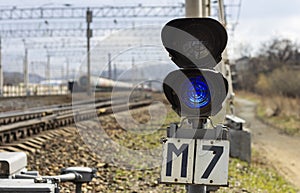 A railway semaphore with a blue signal turned on at a freight station