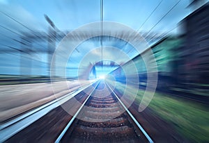 Railway station with cargo wagons in motion blur effect at sunse