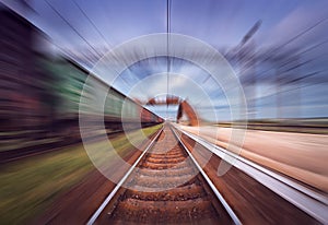 Railway station with cargo wagons in motion blur effect at sunse