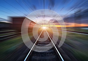 Railway station with cargo wagons in motion blur effect at sunset