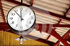 Railway station clock hanging onto the roof of the old train sta