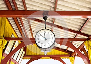 Railway station clock hanging onto the roof of the old train sta