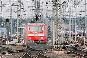 Railway station with modern red commuter train in motion
