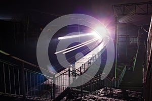 Railway station at night with a passing train