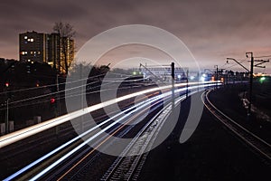 Railway station at night with a passing train