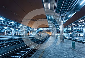 Railway station at night. Train platform in fog. Railroad