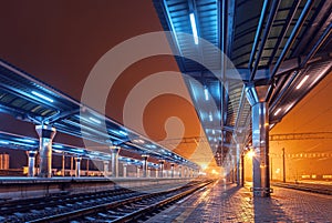 Railway station at night. Train platform in fog. Railroad