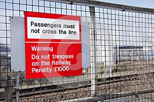 Railway station passengers must not cross rail line danger warning sign do not trespass penalty fine law