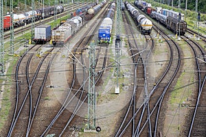 Railway station with railway trains, containers and cisterns.