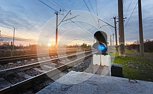 Railway station with semaphore against beautiful sky at sunset