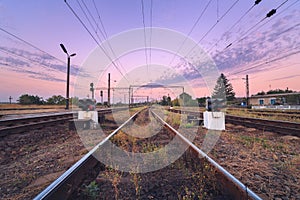 Railway station and traffic light at colorful sunset. Railroad