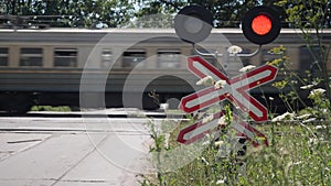 Railway stop sign. Train passing through the crossing. City train rides in the countryside. Car waits until train passes through t