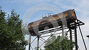 Railway tank on a metal stand. view from the window, water tower against the blue sky. Large water tank, Dryland