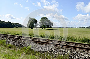 Railway track on the Baltic Sea Island Usedom with meadows, trees and blue sky