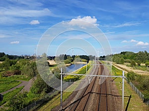 Railway track with nature compensation and wind turbines producing green energy