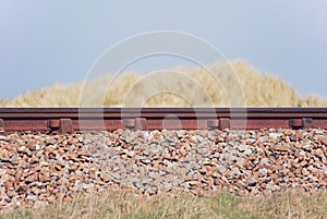 Railway track side view between sand dune grasses