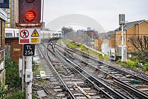 Railway tracks and crossings on rainy day. Train coming in background