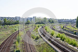Railway tracks curve, with cityscape in the background