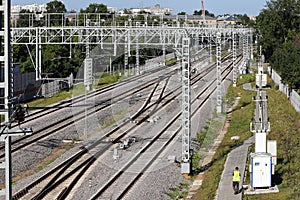 Railway tracks go into the distance. Railway power lines. Lines, diagonals, rhythm. City. Industrial landscape.