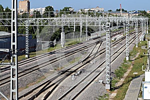 Railway tracks go into the distance. Railway power lines. Lines, diagonals, rhythm. City. Industrial landscape.