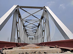 Railway tracks iron bridge unique angle shot with flat sky