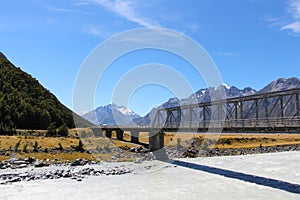 Railway tracks over a metal bridge spanning a river in New Zealand