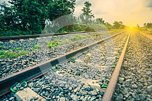 Railway tracks in a rural scene with sunbeam